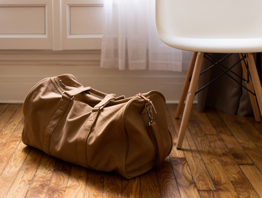 Bag and white chair on wooden floor